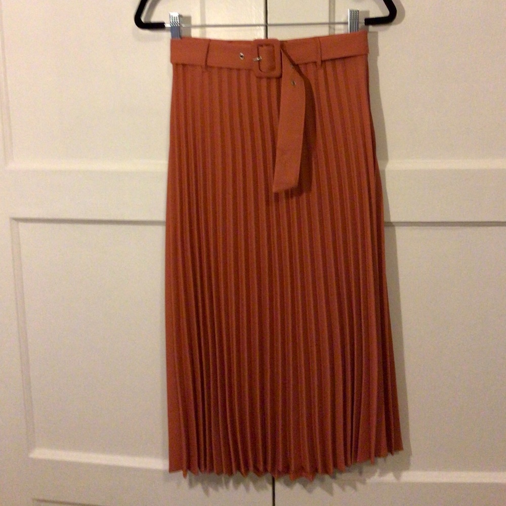 Orange pleated skirt.